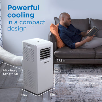 Westinghouse | WPac8000 Portable Air Conditioner shown in use with a man sitting on the couch reading. The image has words that state: power cooling in a compact design. The image shows the unit's dimensions, which are: 12L x 11W x 27.5H in. with a max hose length of 5ft.