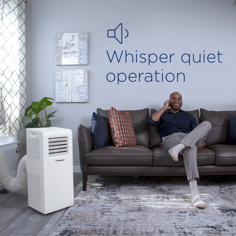 Westinghouse | WPac10000 Portable Air Conditioner shown in use in the living room with a man sitting on the couch on his phone with words saying whisper quiet operation